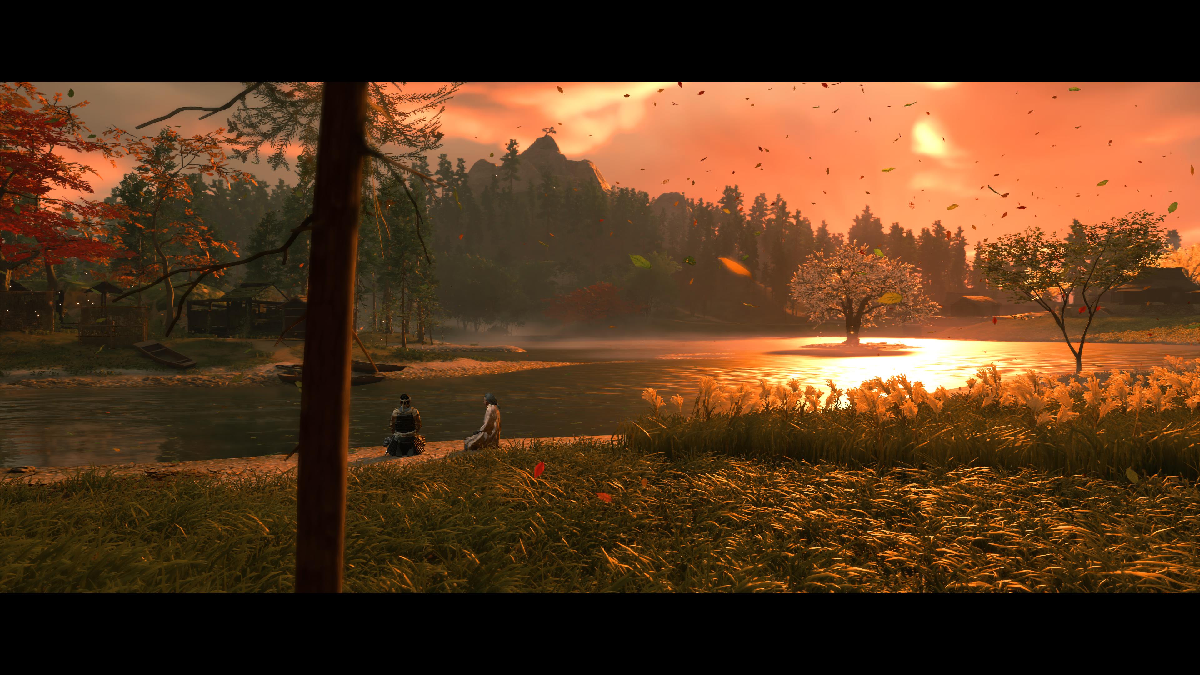 Two People Sitting by a river at sunset